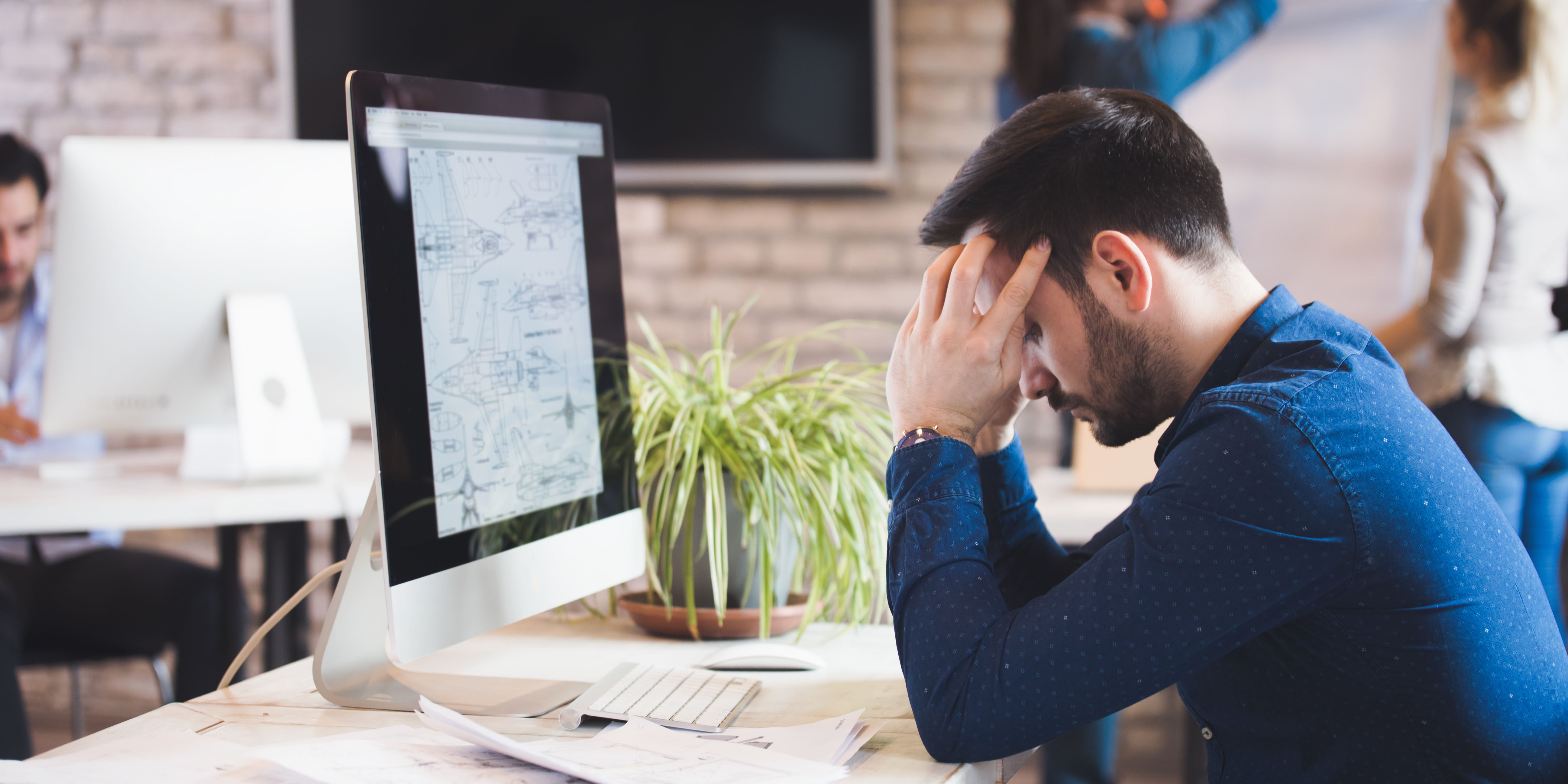 Male employee having trouble concentrating at his desk, possibly due to depression